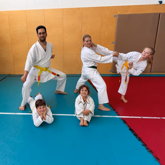 Rodina v kimonách pri spoločnom karate tréningu v telocvični